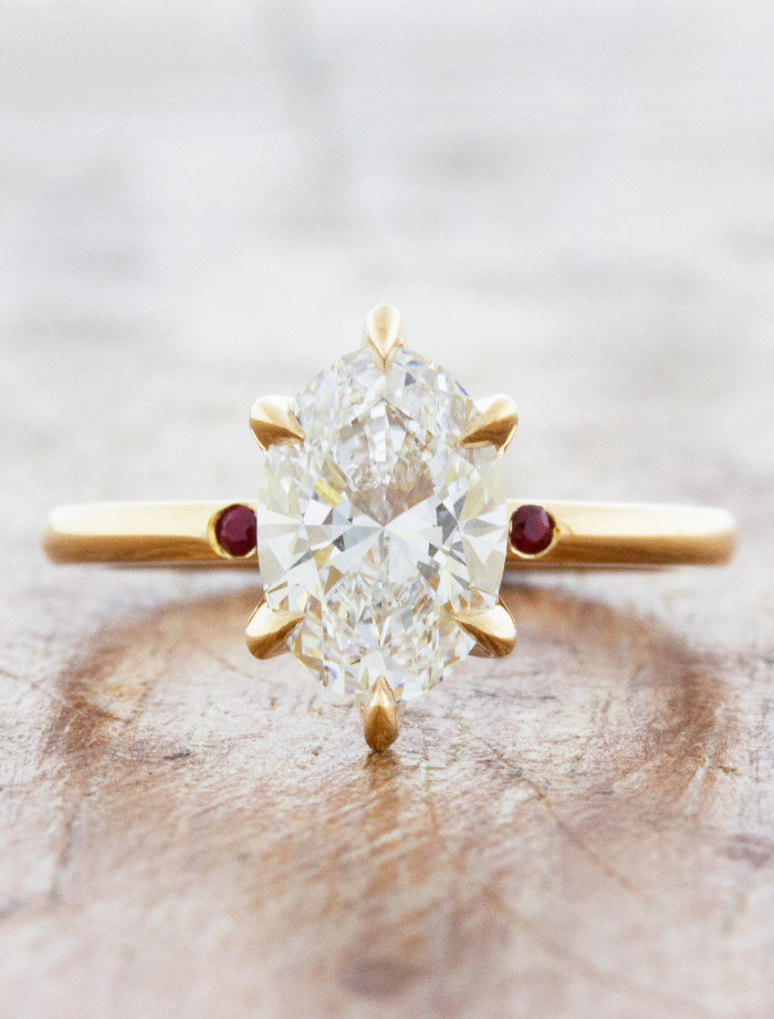caption:Shown with 1.8ct oval diamond in 14k yellow gold, custom ruby accents