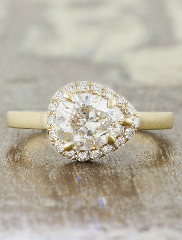 caption:Customized with a horizontally-set pear diamond in 14k yellow gold