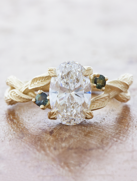 caption:1.53ct oval diamond w/ Montana sapphire accents in 14k yellow gold