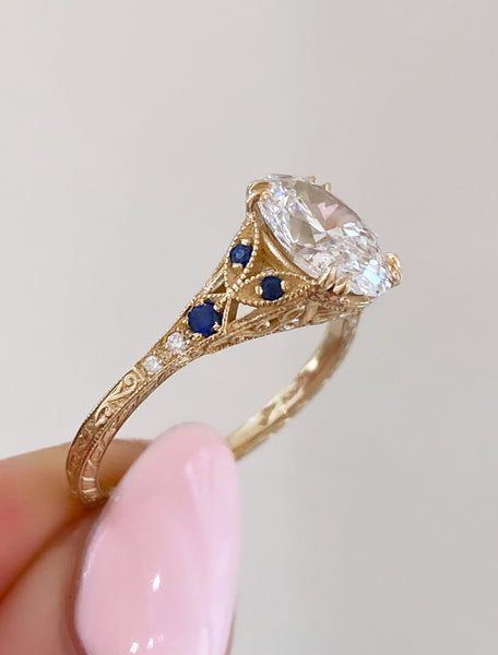caption:1.85ct oval diamond with blue sapphire accents
