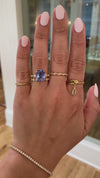 caption:Shown with 5.5ct cornflower blue oval sapphire in 14k yellow gold, stacked with Sarah wedding band
