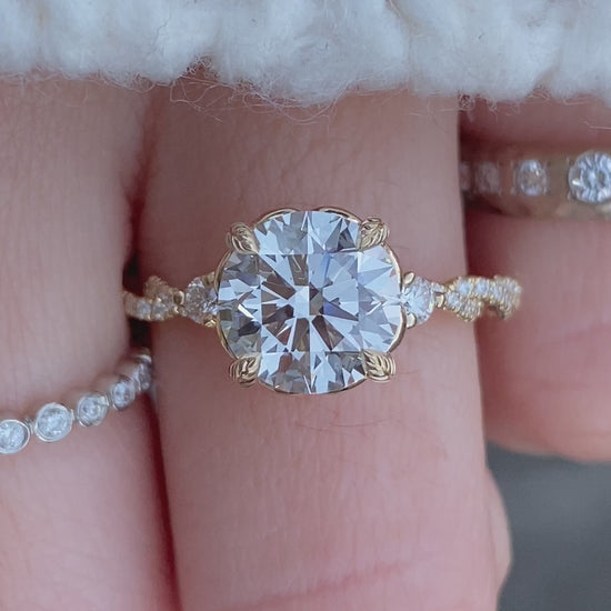 caption:Shown with 2ct round diamond customized with leaf detailing on the center prongs