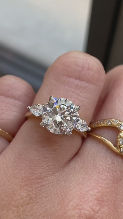 caption:Shown with 3ct round diamond & leaf prongs