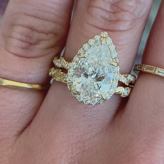 caption:Shown with 3ct pear diamond paired with Koi wedding band