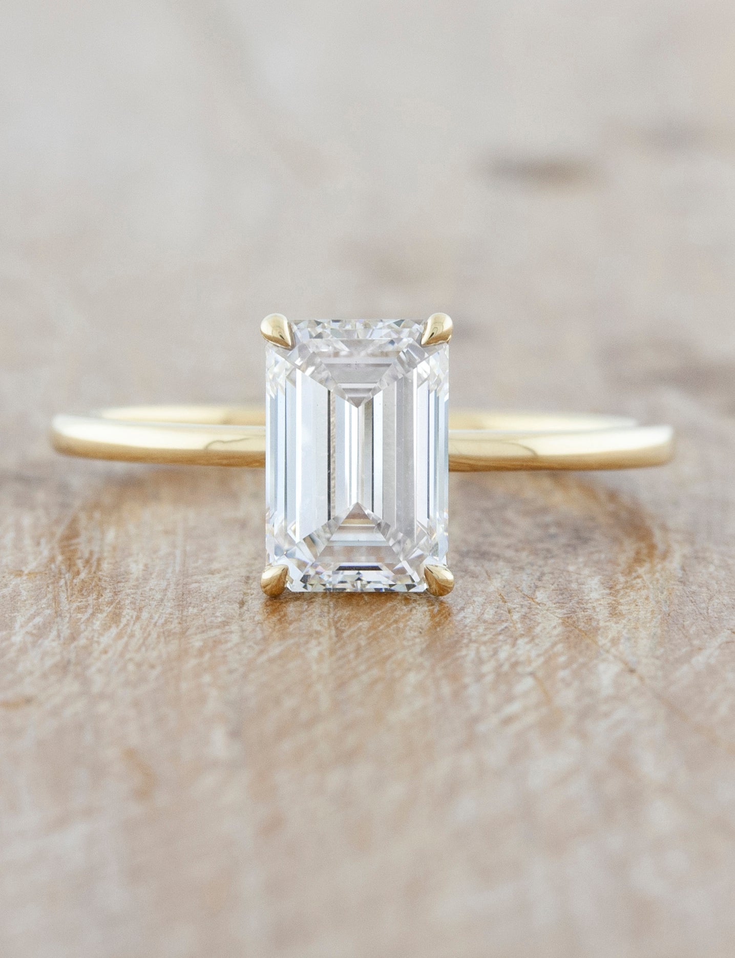 caption:Shown with a 2ct emerald cut in 14k yellow gold