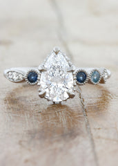 caption:Customized with a 1.25ct pear cut diamond and sapphire side stones