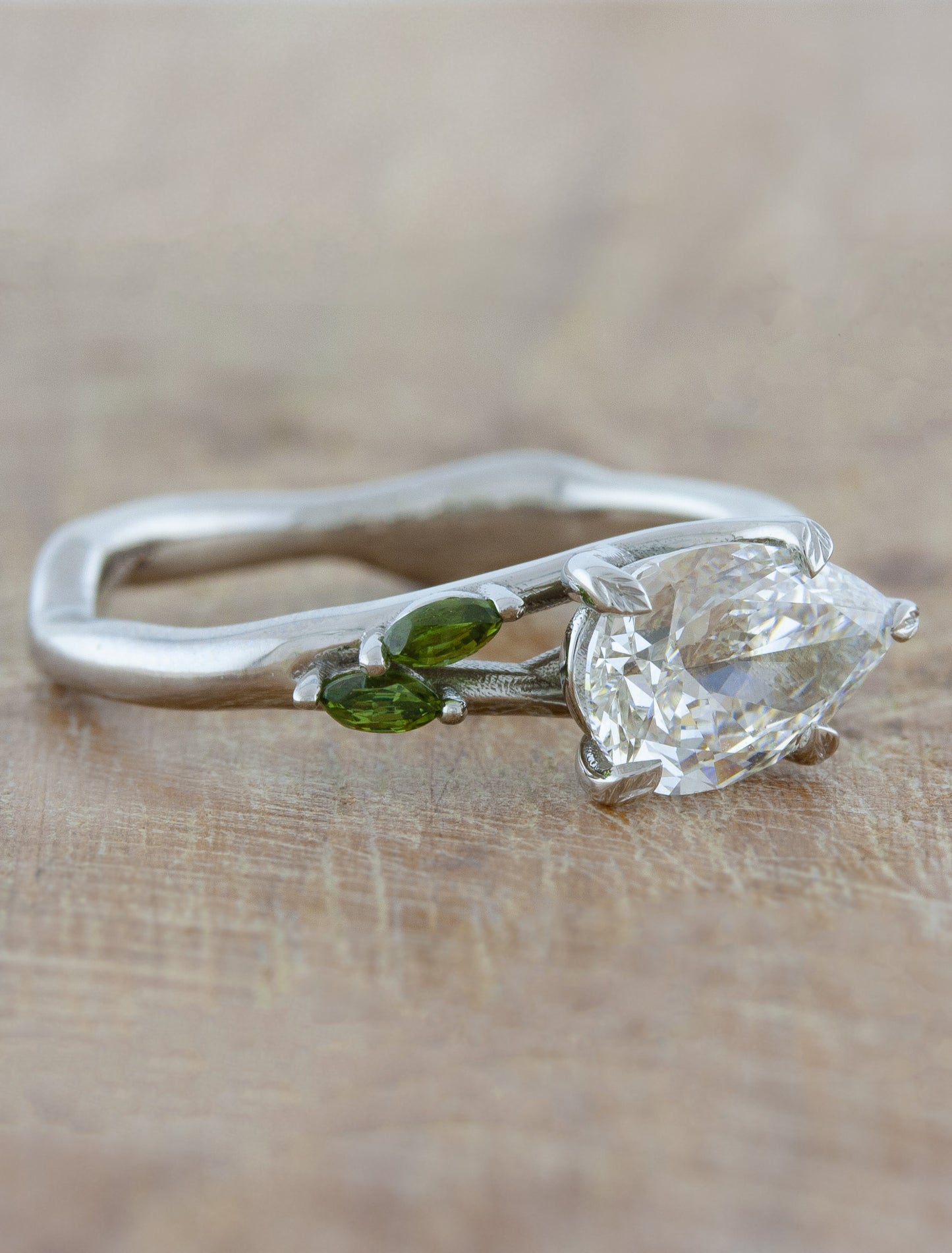 caption:1.20ct pear cut diamond with green sapphire accent stones