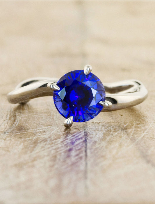 caption: Shown with 1.5ct round blue sapphire in platinum