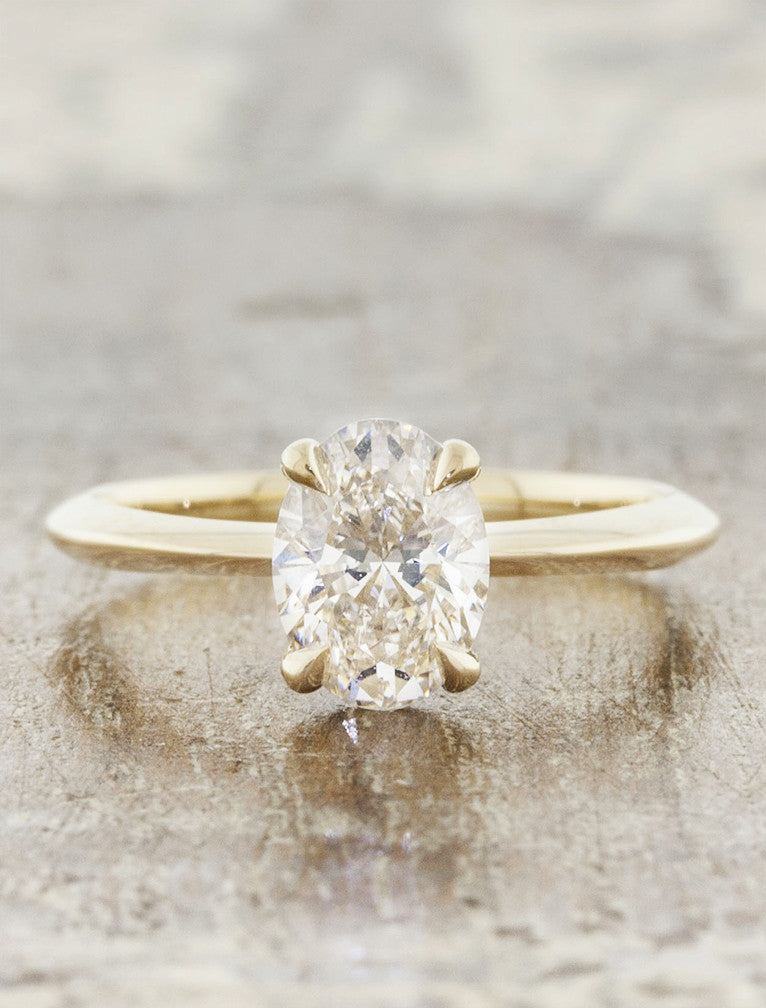 caption:Customized with oval diamond, tapered band, & 4-prong setting in 14k yellow gold