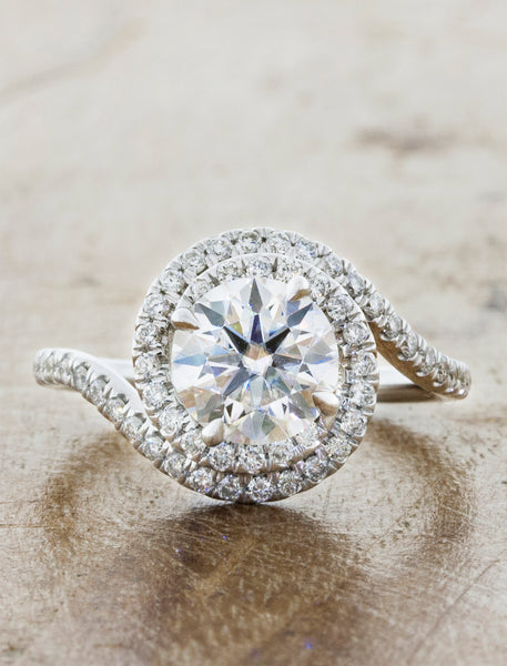 assymetrical swirling halo engagement ring. caption:Shown with 1.25ct diamond option