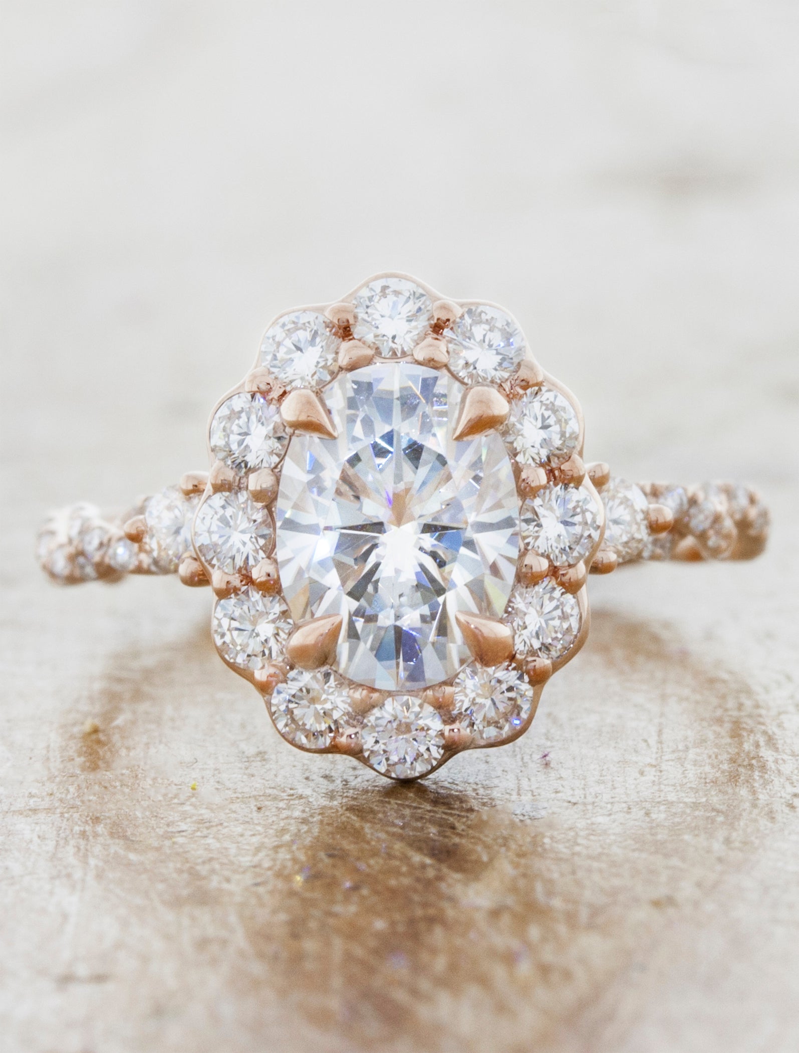 floral inspired oval halo diamond engagement ring. caption:Shown with an 1.2ct oval center diamond