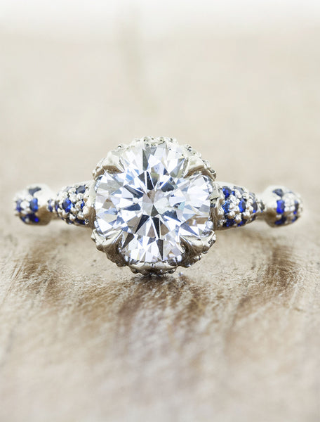 intricate round diamond engagement ring, platinum band with sapphire accents