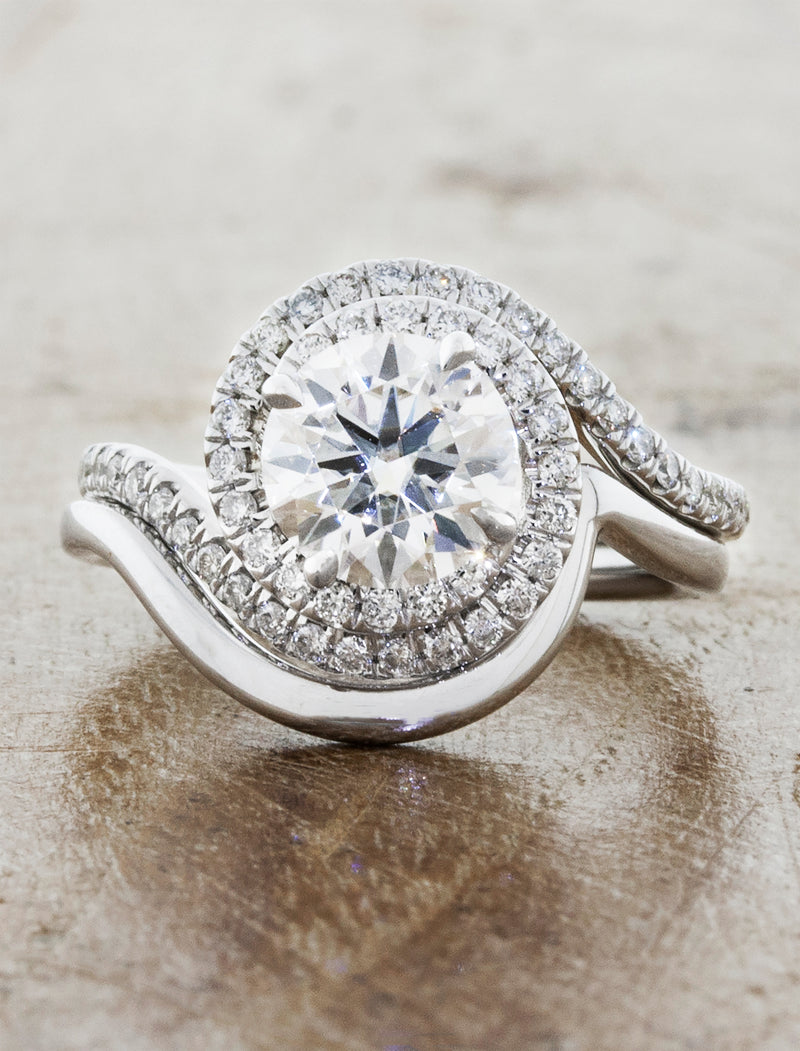 curved wedding band paired with halo engagement ring