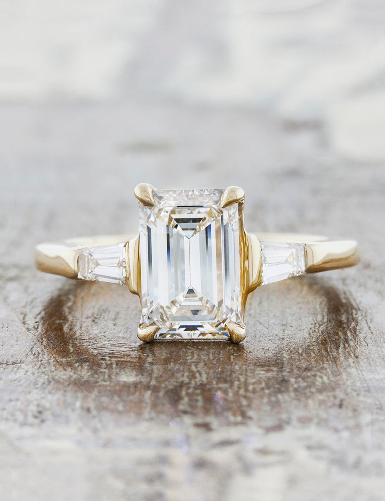 Three stone tapered baguettes;caption:Customized with an 1.70ct. Emerald Cut Diamond 14k Yellow Gold