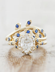 Vintage inspired halo engagement ring. caption:Customized with blue sapphire accents. Shown Sasha wedding band