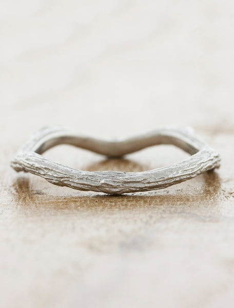 caption:nature inspired curved wedding band in platinum